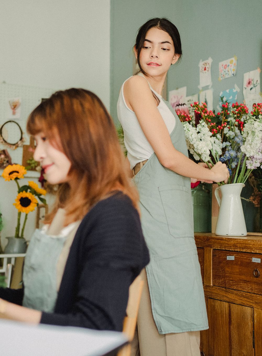 A florist arranging a seasonal bouquet on a wooden workbench